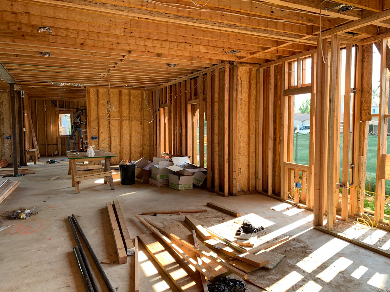 Mastering the First Impression: Your intriguing post title goes here Sunlit interior with wood framing, showcasing home construction progress.