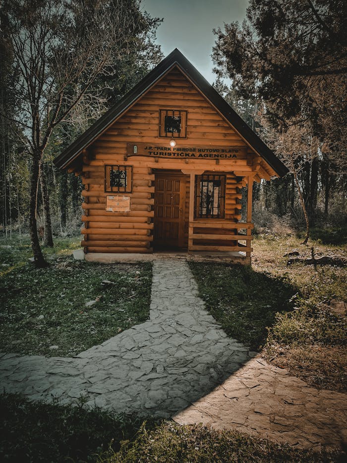 Services Charming wooden cabin amidst trees, capturing a serene forest atmosphere.